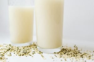 2 glasses of hemp milk with seeds on table