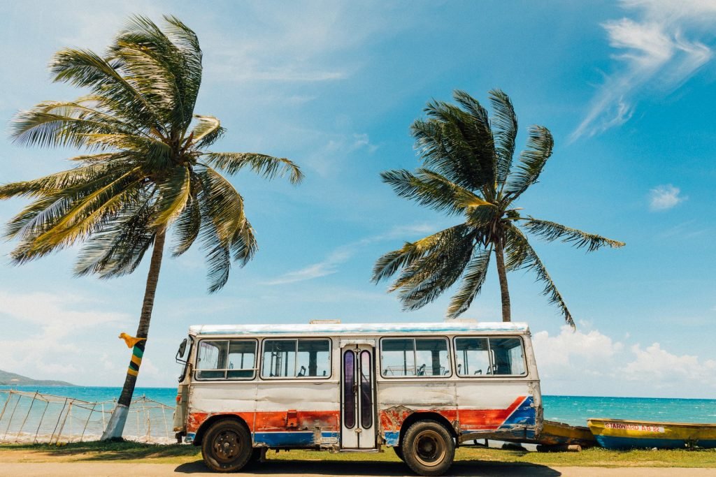 Jamaica - old bus sitting in front of ocean and palm trees