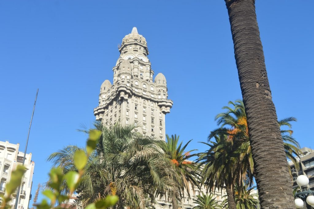 Uruguay - cream old building with palm trees below