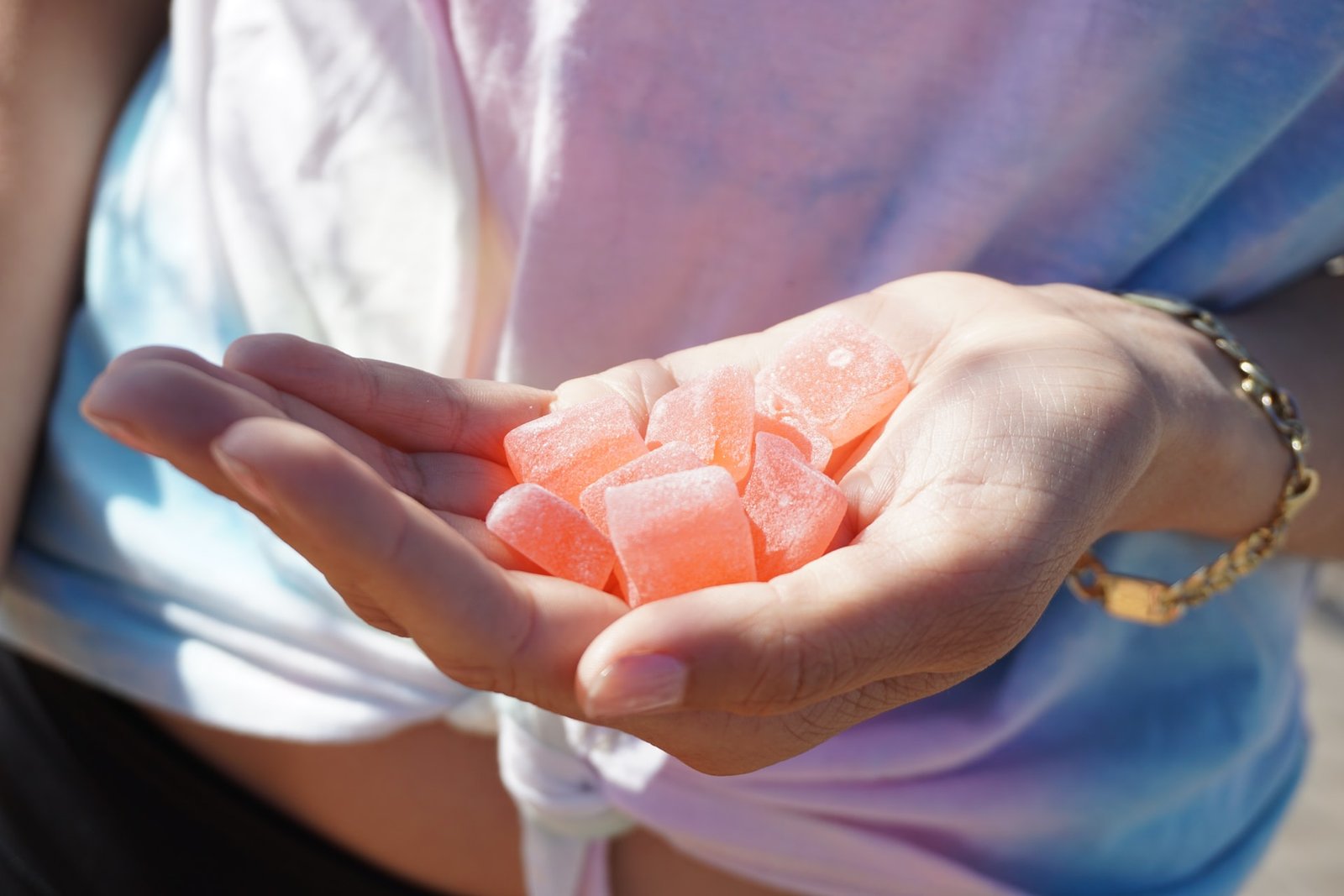 female holding red gummies in hand