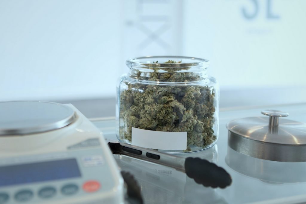 weed in glass jar next to scales